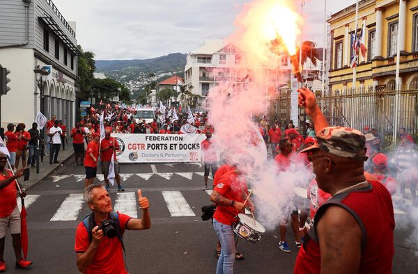 Demonstrators wave flares as they march during a rally in Saint-Denis de la Reunion on the French Indian island of La Reunion on January 19, 2023, as part of a strike by workers held to protest the French government&#x27;s proposed pension reform to raise the legal retirement age from 62 to 64. (Photo by Richard BOUHET / AFP) - Sputnik International