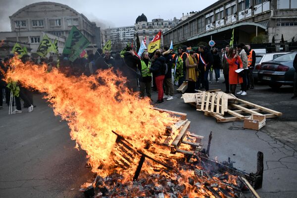 Wooden pallets burn as demonstrators gather during a rally called by French trade unions outside the Gare de Lyon, in Paris on January 19, 2023. (Photo by STEPHANE DE SAKUTIN / AFP) - Sputnik International