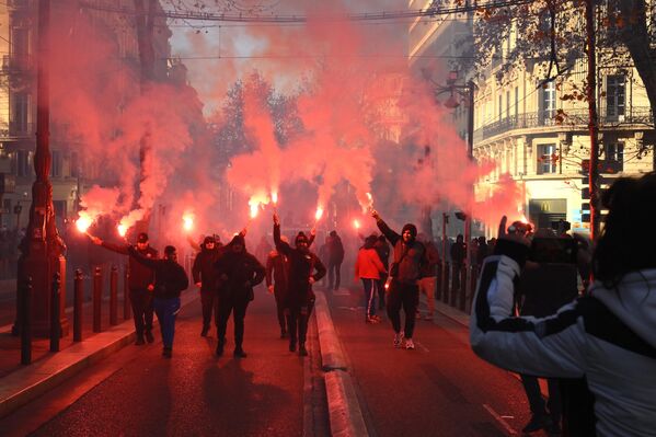 Protesters wave flares during a rally called by French trade unions against the government pension reform plan in Marseille, southern France, on January 19, 2023.  - Sputnik International
