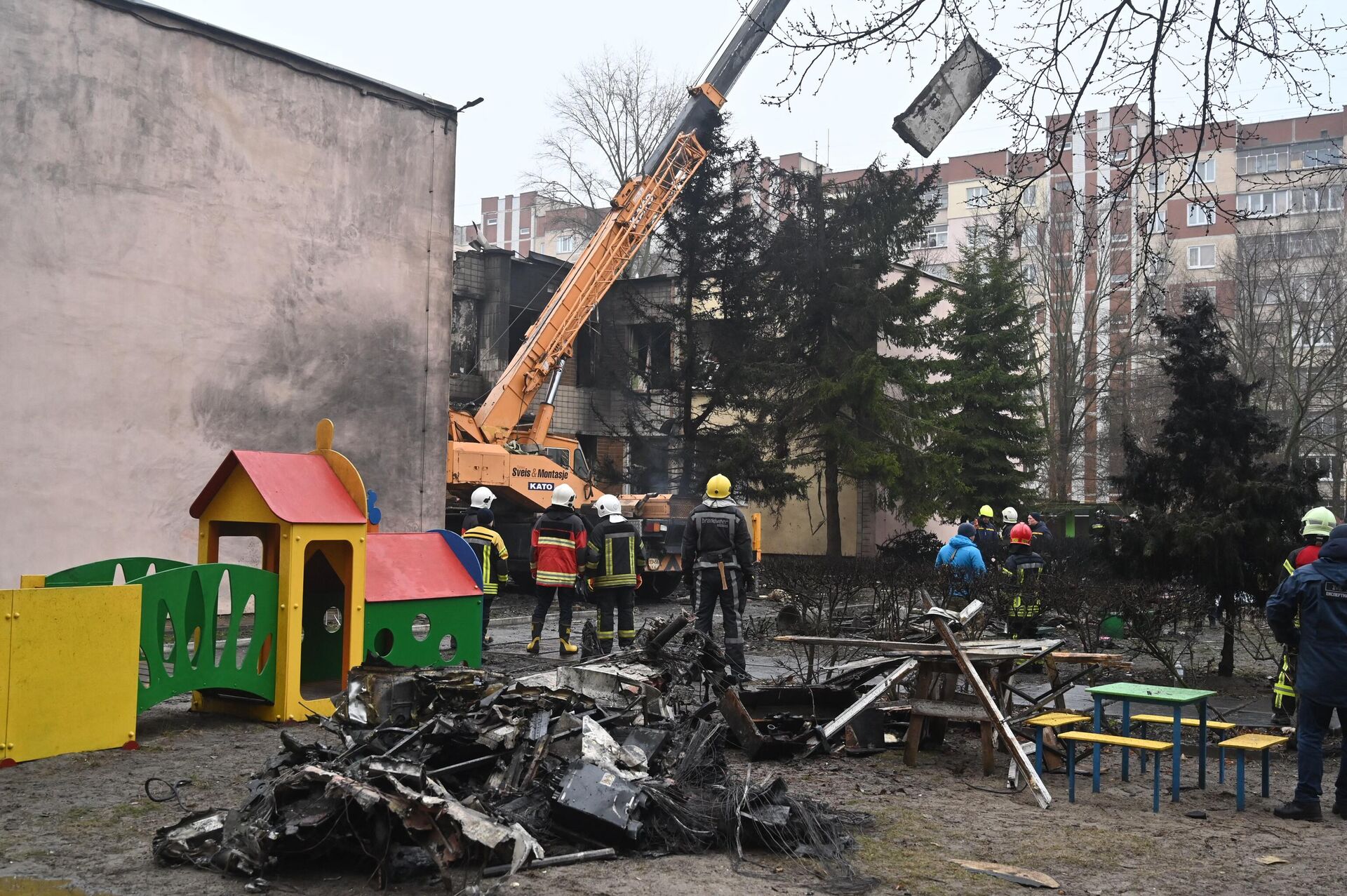 Firefighters work near the site where a helicopter crashed near a kindergarten in Brovary, outside the capital Kiev on January 18, 2023 - Sputnik International, 1920, 19.01.2023