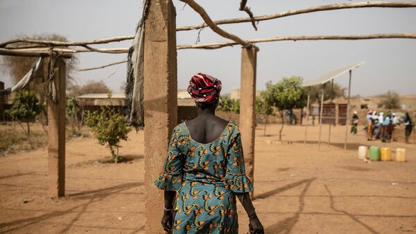 A displaced woman walks with a kettle Monday Feb. 8, 2021 in the Kaya camp, 100 kms North of Ouagadougou, Burkina Faso.  - Sputnik International