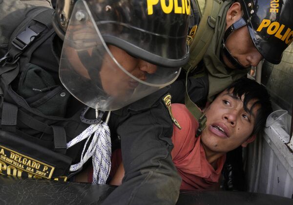 An anti-government protester who traveled to the capital from across the country to march against Peruvian President Dina Boluarte, is detained and thrown on the back of police vehicle during clashes in Lima, Peru, Thursday, January 19, 2023.  - Sputnik International