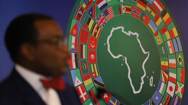 A logo with various national flags of countries around the world are seen as Akinwumi Adesina, president of the African Development Bank Group, speaks at the African Development Bank’s Annual meeting in Accra, Ghana, on May 23, 2022.  - Sputnik International