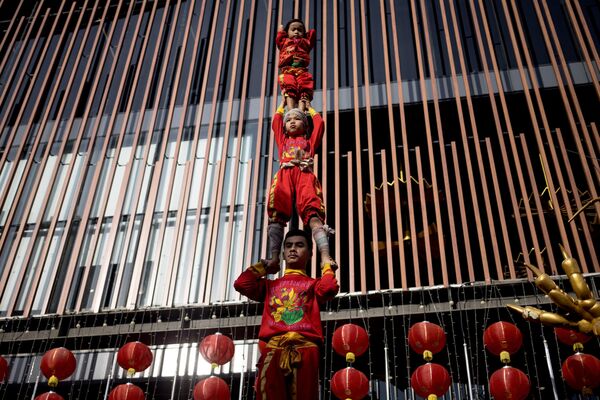 Young acrobats form a human tower during a performance on the eve of lunar new year in the Chinatown area of Bangkok on 21 January 2023. - Sputnik International