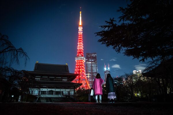 People visit Zojoji temple as Tokyo Tower is lit in red to celebrate the Chinese Lunar New Year in Tokyo on 21 January 2023. - Sputnik International