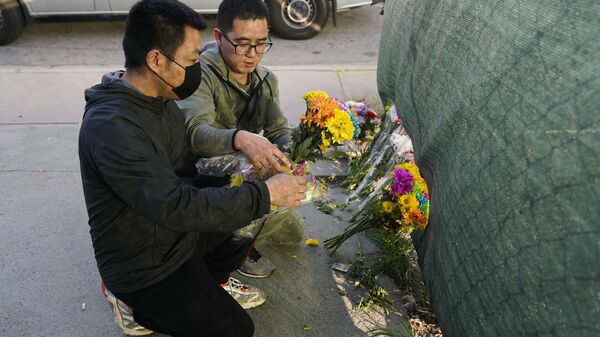Two men place flowers near Star Dance Studio to honor victims killed in a shooting in Monterey Park, Calif., Sunday, January 22, 2023.  - Sputnik International