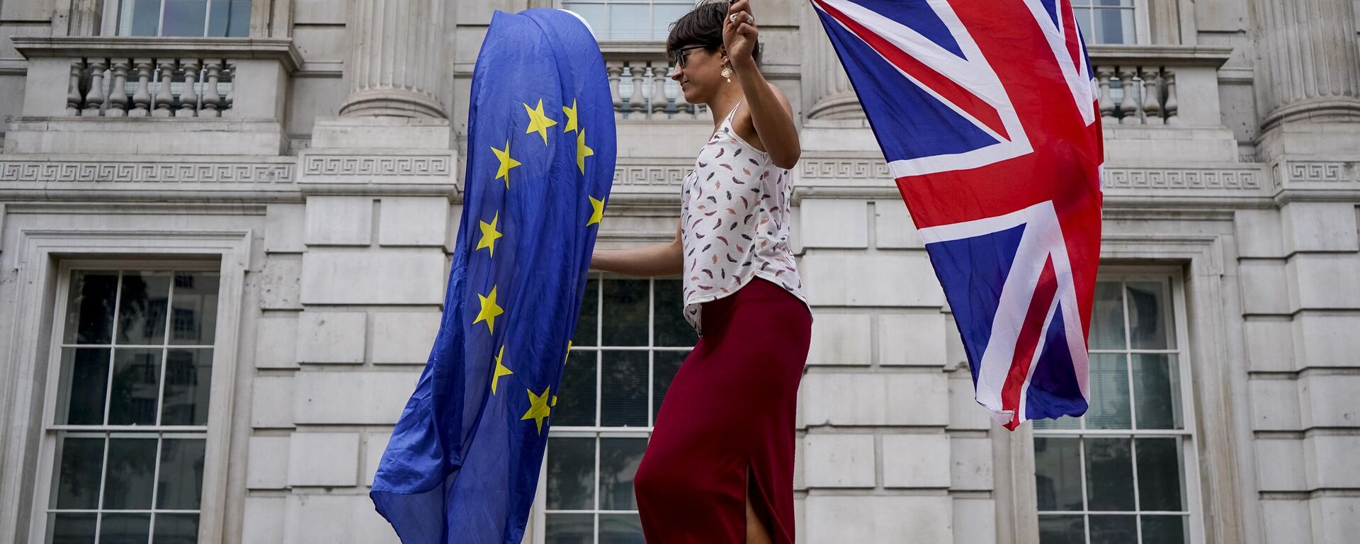 An anti-Brexit demonstrator whirls an EU and Union Flag during a demonstration against the British government's move to suspend parliament in the final weeks before Brexit outside Downing Street in London on August 31, 2019 - Sputnik International, 1920, 24.01.2023