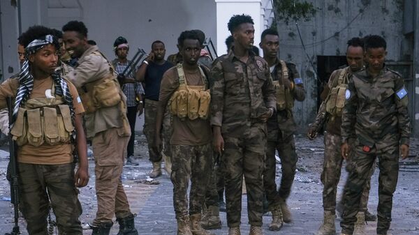 Police officers stand near the bodies of alleged Al-Shabaab militants who have been killed after the siege at the Mogadishu Municipality Headquaters in Mogadishu on January 22, 2023 - Sputnik International