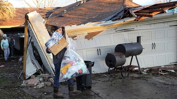 Mario Mendoza carries items out of a friend's storm-damaged home Tuesday, Jan. 24, 2023, in Pasadena, Texas. A powerful storm system took aim at Gulf Coast Tuesday, spawning tornados that caused damage east of Houston. - Sputnik International