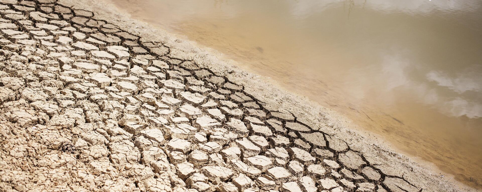 A dried out bank of a nearly water empty dam is pictured on a farm in Piket Bo-berg, Piketberg, north of Cape Town, on March 7, 2018 as  a result of a three-year-long drought - Sputnik International, 1920, 25.01.2023