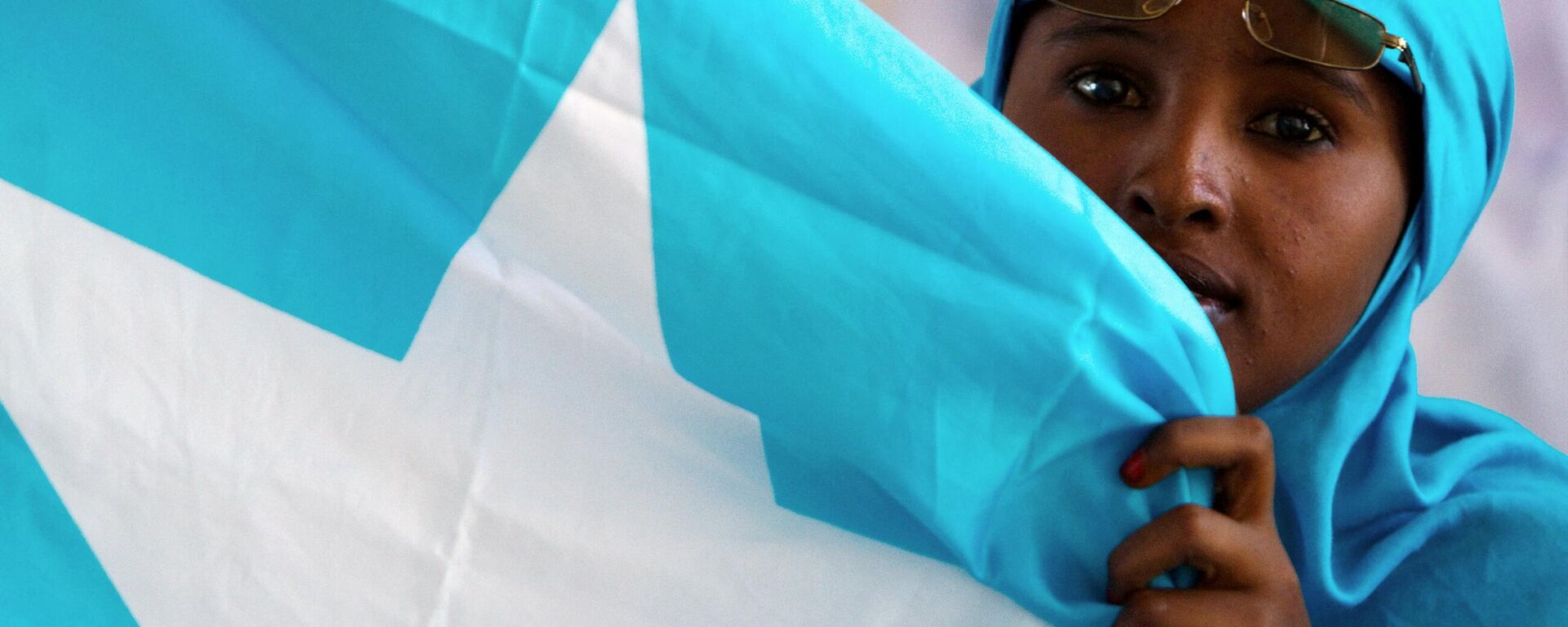 A Somali woman holds the national flag during a ceremony marking President Sheikh Sharif Sheikh Ahem's first year in office at the Villa Somalia presidential palace in Mogadishu on January 29, 2010 - Sputnik International, 1920, 25.01.2023