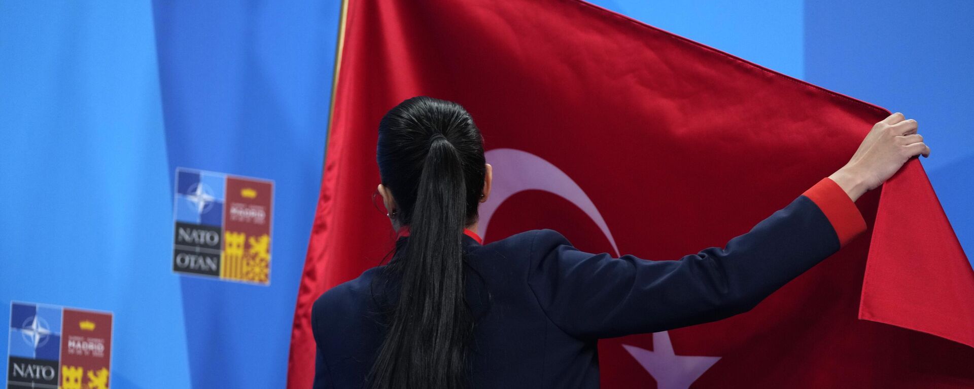A member of the Turkish delegation adjusts the flag prior to an address by Turkish President Recep Tayyip Erdogan at a NATO summit in Madrid, Spain  - Sputnik International, 1920, 27.02.2023