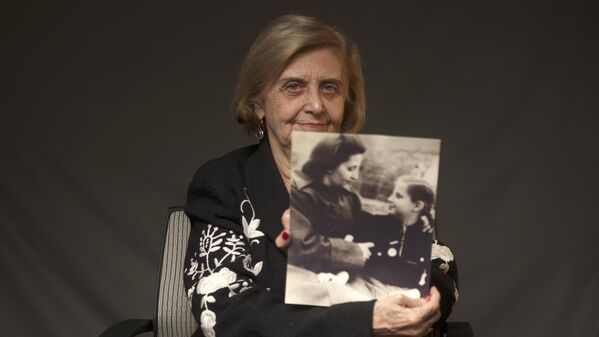 In this photo provided by the World Jewish Congress, Tova Friedman, an 82-year-old Polish-born Holocaust survivor, holds a photograph of herself as a child with her mother, who also survived the Nazi death camp Auschwitz, in New York, Friday, Dec.13, 2019.  (World Jewish Congress via AP) - Sputnik International