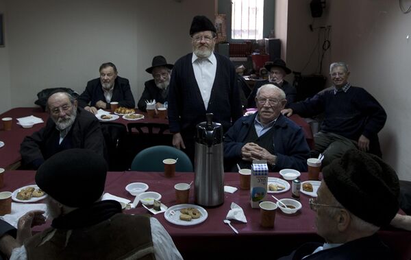 In this January 18, 2012, photo, Ultra Orthodox Jewish holocaust survivors hold a weekly meeting at the Misgav Lakashish seniors&#x27; club in the religious neighborhood of Mea Shearim in Jerusalem. It&#x27;s a huge question for observant Jews: How can one still believe in a merciful God after suffering through the worst genocide in history? Members of Israel&#x27;s most devout group are unbowed in their faith. (AP Photo/Sebastian Scheiner) - Sputnik International