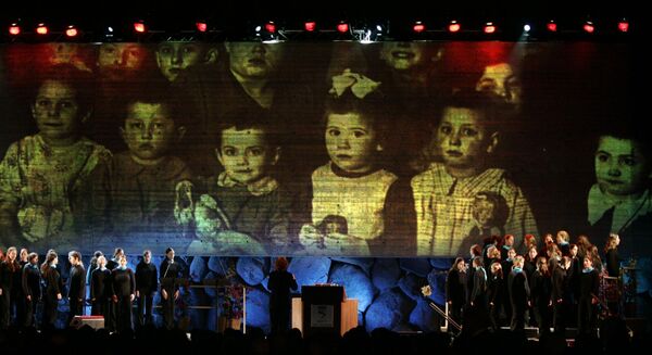 Backdropped by a projection of Holocaust victims, a choir performs during the official opening ceremony for the new Yad Vashem Holocaust Museum in Jerusalem, March 15, 2005.  Leaders and dignitaries from some 40 countries attended the opening of a US$56 million museum that focuses on the personal tragedies of the six million Jews who perished by the Nazis in the Holocaust. - Sputnik International