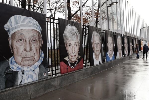 Larger-than-life portraits by Italian photographer Luigi Toscano line a fence bordering United Nations headquarters, January 23, 2018, in New York. The images are part of the exhibition &quot;Survivors, Victims and Perpetrators,&quot; in conjunction with the Lest We Forget project, commemorating Holocaust victims and survivors. (AP Photo/Kathy Willens) - Sputnik International