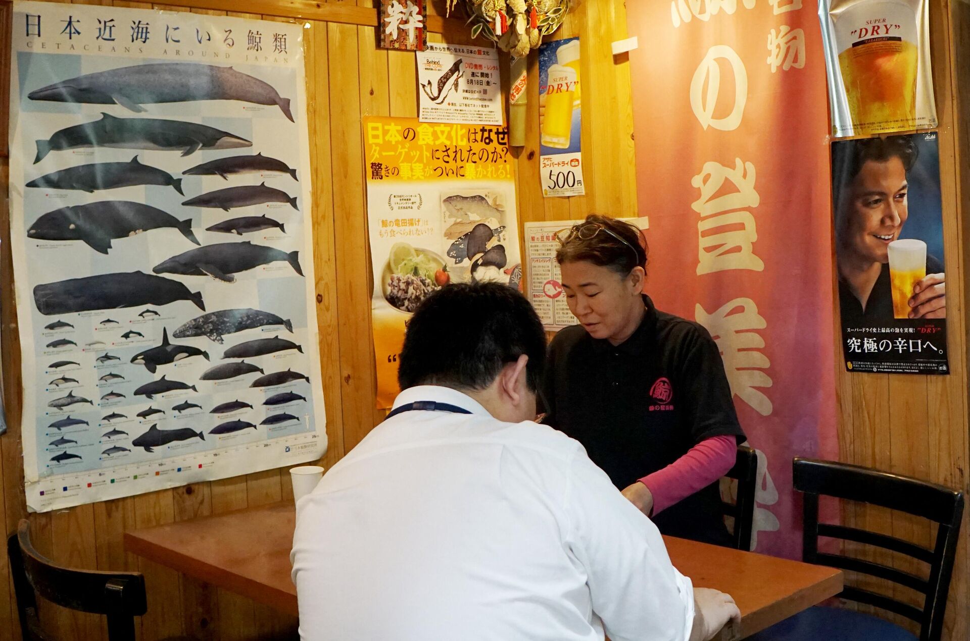 This July 2, 2019 picture shows Tsukiji's whale meat restaurant Tomisui manager Sumiko Koizumi (R) talking with whale meat dealer at her restaurant in Tokyo - Sputnik International, 1920, 26.01.2023