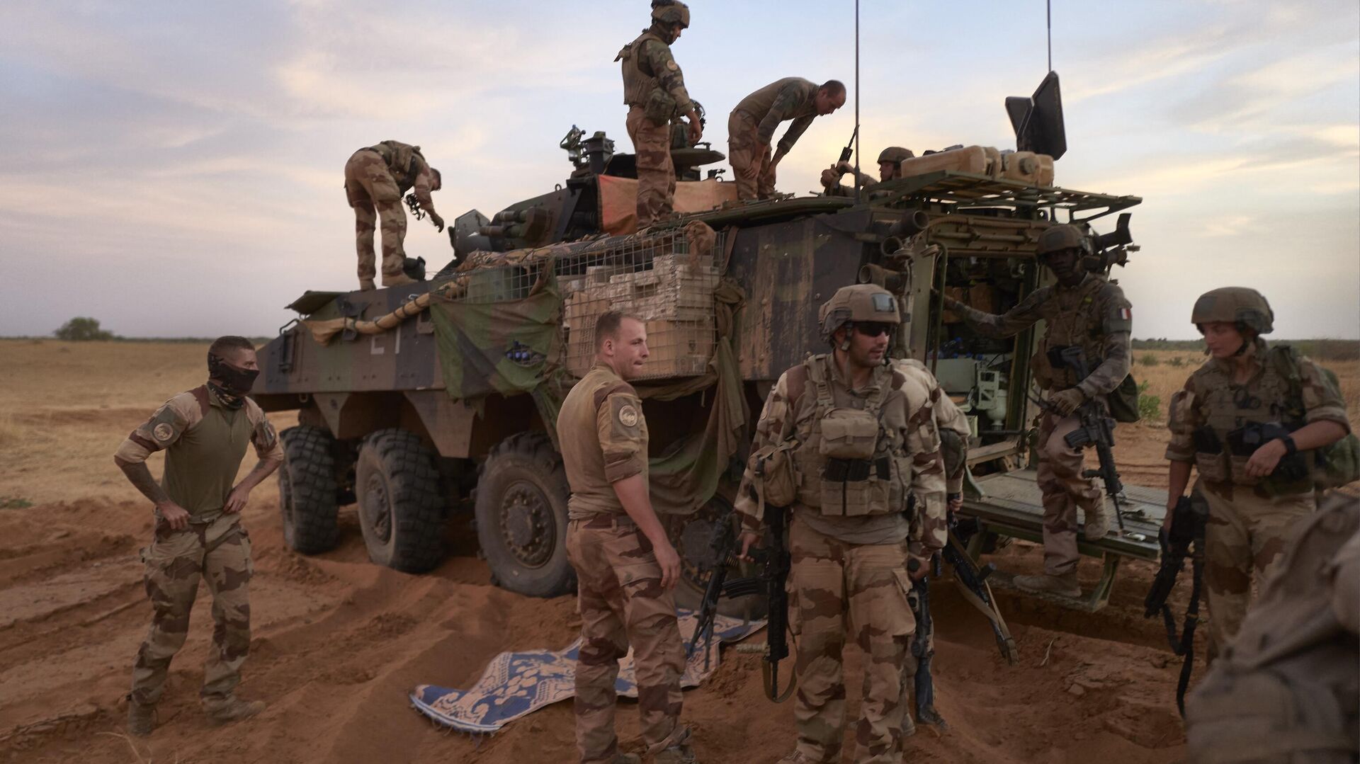 In this file photo taken on November 09, 2019, soldiers of the French Army stand next to an Armoured Personnel Carrier (APC) used to patrol the Soum region, during the Bourgou IV operation in northern Burkina Faso. - France has received a request from junta-ruled Burkina Faso to withdraw its troops from the Sahel country and will do so within a month, the fromeign ministry said January 25, 2023.  - Sputnik International, 1920, 26.01.2023