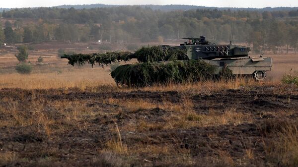 A Leopard 2 battle tanks of the German armed forces Bundeswehr drives during a visit by the German Chancellor to the German Bundeswehr's troops during a training exercise at the military ground in Ostenholz, northern Germany, on October 17, 2022 - Sputnik International