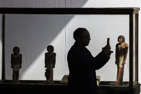 A man takes pictures near pharaoh statues during a press conference at the Saqqara necropolis, where a gold-laced mummy and four tombs including of an ancient king&#x27;s &quot;secret keeper&quot; were discovered, south of Cairo on January 26, 2023.  - Sputnik International