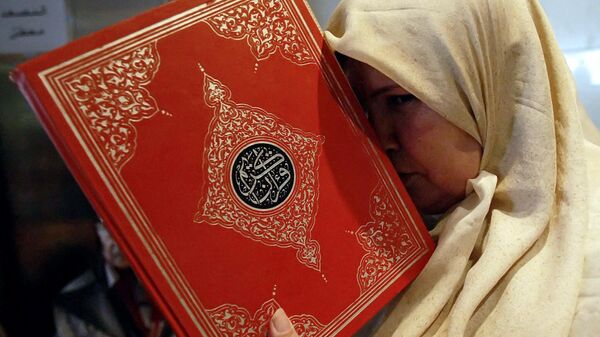A Lebanese woman displaced from a border village in the south of the country holds a copy of the Quran at a hotel in the port city of Tyre, July 22, 2006. - Sputnik International