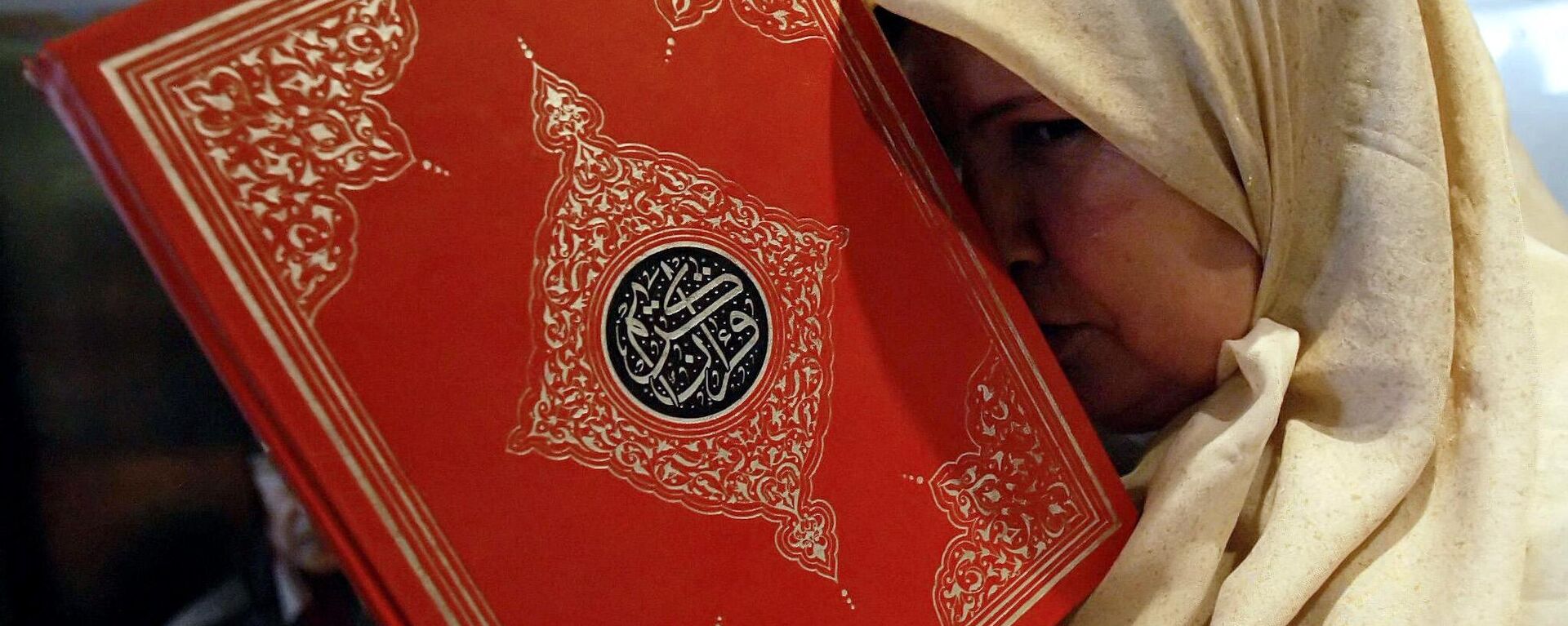 A Lebanese woman displaced from a border village in the south of the country holds a copy of the Quran at a hotel in the port city of Tyre, July 22, 2006. - Sputnik International, 1920, 27.01.2023