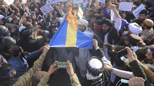 Afghans shout slogans as they burn a flag of Sweden during a protest against the burning of the Koran by Swedish-Danish far-right politician Rasmus Paludan, after Friday prayers in Jalalabad on January 27, 2023. - Sputnik International