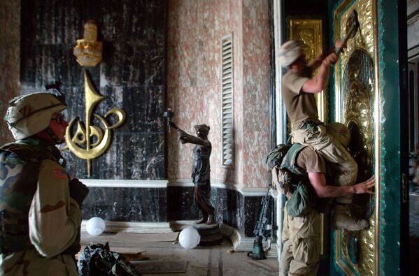 US Army soldiers pry off the presidential seal from the front door of one of Saddam Hussein&#x27;s palaces in Baghdad, Iraq, Tuesday, April 8, 2003. The palace was the second they had secured in as many days. Both lavish buildings were heavily damaged by previous US Air Force bombing. (AP Photo/John Moore) - Sputnik International