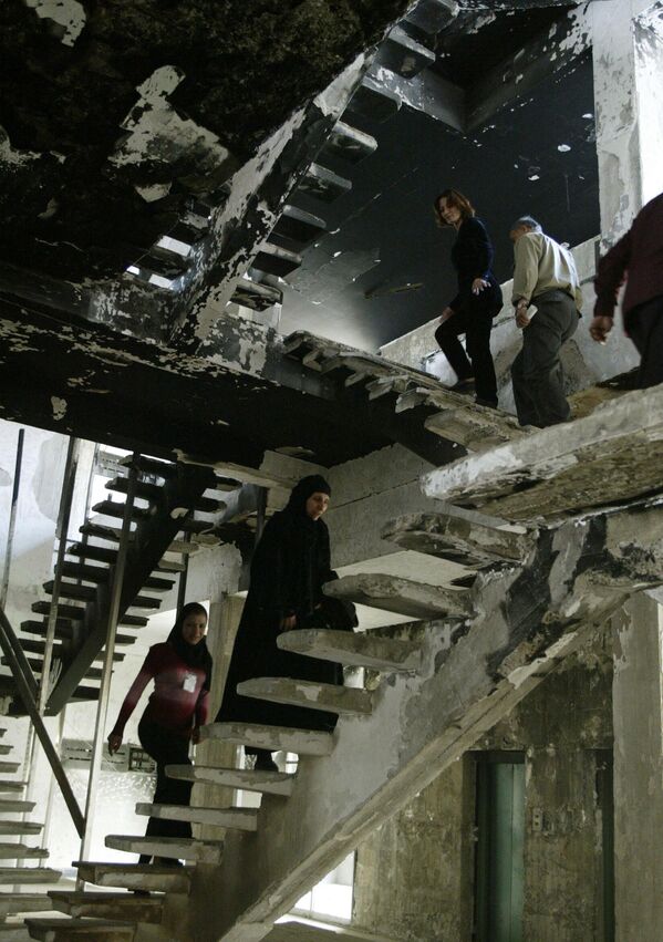 Employees of Baghdad&#x27;s al-Muthanna Library climb the stairs inside a burnt out section of the building on March 13, 2004, nearly one year after it was ransacked by looters. The library was looted and set on fire on April 13, 2003, four days after the fall of Baghdad to US-led coalition forces. Known as the National Library, it was built in 1961 and was home to Iraq&#x27;s national archives.  AFP PHOTO/Joseph BARRAK (Photo by JOSEPH BARRAK / AFP) - Sputnik International