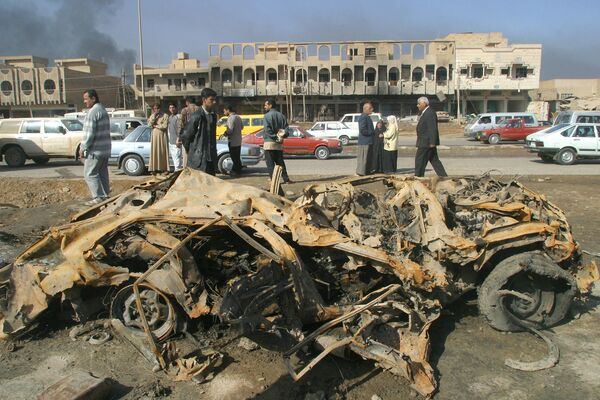 A burnt out wrecked car is seen in the al-Shaab neighborhood in Baghdad on March 27, 2003. A missile hit the neighborhood, leaving 17 people dead and dozens injured. Iraq announced that more than 350 people had been killed in the first week of the war, and accused the United States of dropping cluster bombs on civilians in Baghdad. AFP PHOTO/Karim SAHIB (Photo by KARIM SAHIB / AFP) - Sputnik International