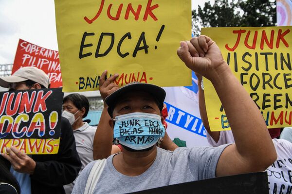 Demonstrators protest against the Enhanced Defense Cooperation Agreement between the US and the Philippines, calling it &quot;junk&quot;. (Photo by Ted ALJIBE / AFP) - Sputnik International