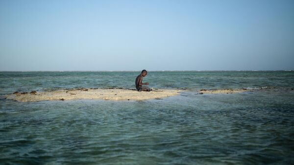 A young Zanzibari fisherman takes a break on a sandbank in the Indian Ocean off the coast of Matemwe village, northeastern Zanzibar, Tanzania, Wednesday, Jan. 28, 2015. - Sputnik International