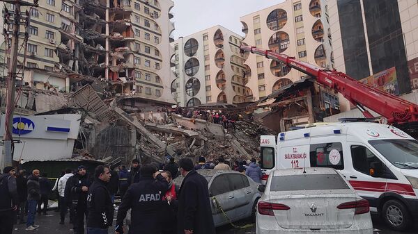 Rescue workers and medical teams try to reach trapped residents in a collapsed building following an earthquake in Diyarbakir, southeastern Turkey, early Monday, Feb. 6, 2023.  - Sputnik International