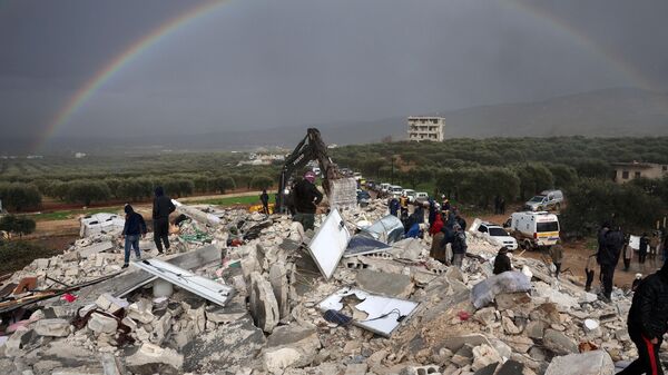 Residents search for victims and survivors amidst the rubble of collapsed buildings following an earthquake in the village of Besnaya in Syria's rebel-held northwestern Idlib province on the border with Turkey, on February 6, 2022. - Sputnik International