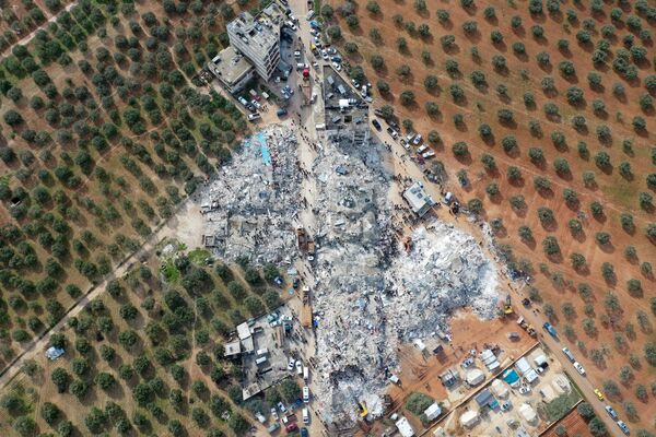 An aerial view showing residents searching for victims and survivors amidst the rubble of collapsed buildings after an earthquake in the town of Besnia near the town of Harim, in Syria&#x27;s rebel-held north-western Idlib province on the border with Turkey on 6 February 2023. - Sputnik International