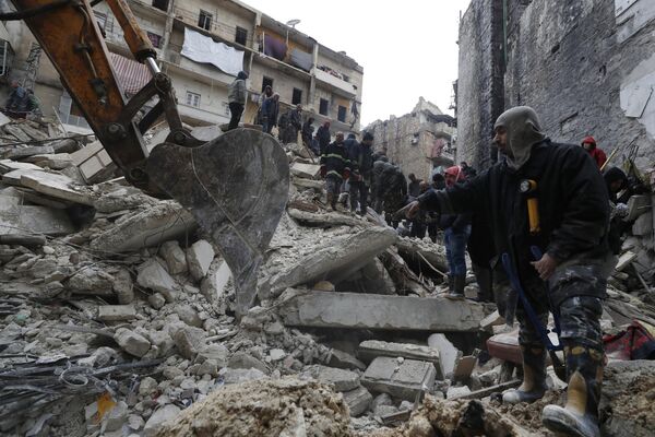 Syrian Civil Defense workers and security forces search through the wreckage of collapsed buildings, in Aleppo, Syria on Monday 6 February 2023. - Sputnik International