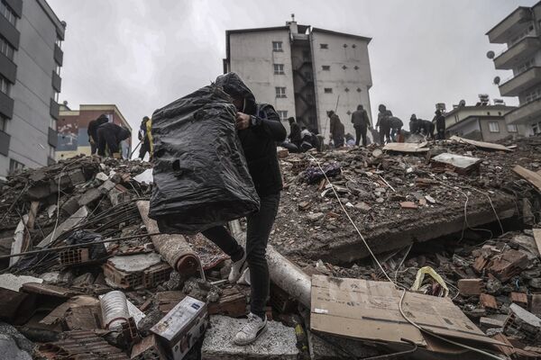 People and emergency teams search for people in the rubble of a destroyed building in Gaziantep, Turkey on Monday 6 February 2023. - Sputnik International