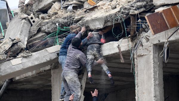 Residents retrieve an injured girl from the rubble of a collapsed building following an earthquake in the town of Jandaris, in the countryside of Syria's northwestern city of Afrin in the rebel-held part of Aleppo province, on February 6, 2023.  - Sputnik International