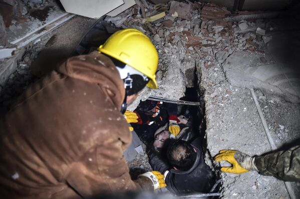 Emergency workers and medics rescue a woman from the debris of a collapsed building in Elbistan, Kahramanmaras, in southern Turkey on Tuesday 7 February 2023. - Sputnik International
