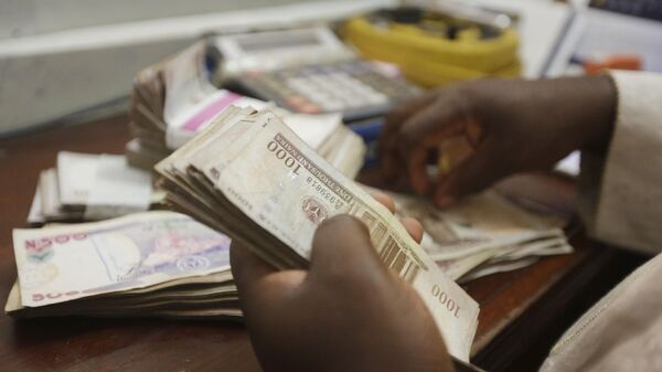 A money changer counts Nigerian naira currency at a bureau de change, in Lagos Nigeria, Oct. 20, 2015 - Sputnik International