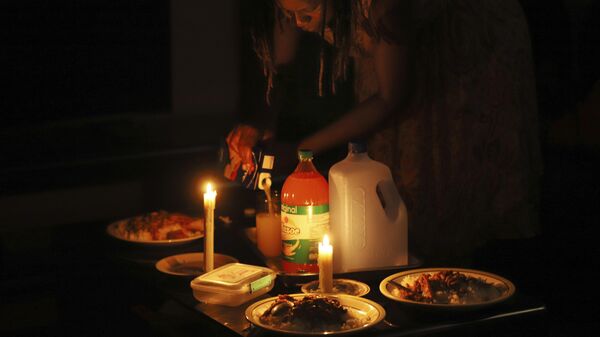 A woman prepares a meal by candle light at her home in Harare, Zimbabwe, Tuesday, Dec. 20, 2022. A buoyant holiday mood is not lifting the country which is coping with widespread power outages and the world's highest food inflation.  - Sputnik International