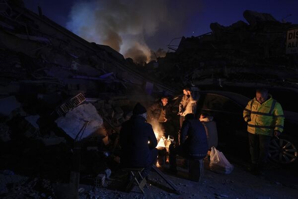Survivors try to warm up near a bonfire in Antakya, southern Turkiye. - Sputnik International