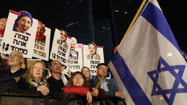 Israelis hold placards in Tel Aviv on January 28, 2023 during a protest against controversial government plans to give lawmakers more control of the judicial system.  - Sputnik International
