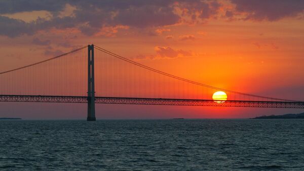 In this May 31, 2002 file photo, the sun sets over the Mackinac Bridge and the Mackinac Straits as seen from Lake Huron. - Sputnik International