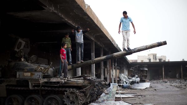 Boys play on a destroyed tank inside a vegetable market in Tripoli Street, the former center of fighting between the rebels and Moammar Gadhafi's forces in Misrata, Libya, Sunday, May 22, 2011.   - Sputnik International