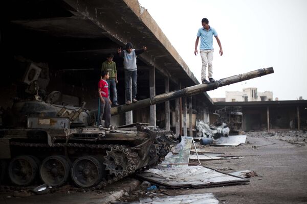 Boys play on a destroyed tank inside a vegetable market in Tripoli Street, the former center of fighting between the rebels and Muammar Gaddafi&#x27;s forces in Misrata, Libya, on Sunday 22 May 2011.   - Sputnik International