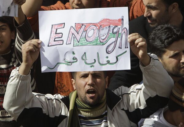 A Libyan protester holds up a sign against Libyan Leader Muammar Gaddafi during a demonstration, in Tobruk, Libya on Wednesday 23 February 2011. Heavy gunfire broke out in Tripoli as forces loyal to Gaddafi tightened their grip on the Libyan capital and anti-government protesters, including top government officials and diplomats, turned against the long-time leader and claimed control of several cities elsewhere. - Sputnik International