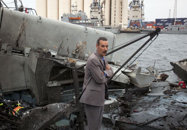 In this photo taken on 20 May 2011, a Libyan official inspects damage on ships moored at the seaport in Tripoli, Libya. NATO fighter jets struck three ports in bombing runs overnight, targeting Gadhafi&#x27;s navy. - Sputnik International