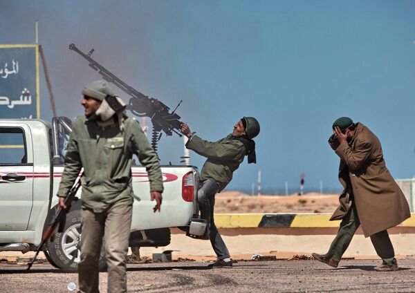 An opposition fighter fires a machine gun at a fighter jet in Ras Lanuf city. - Sputnik International