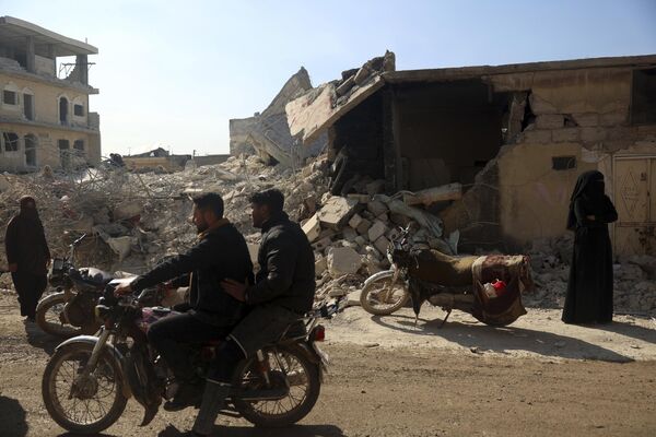 People remove their furniture and household appliances from a collapsed building after a devastating earthquake in the town of Jinderis, Aleppo province, Syria on Tuesday 14 February 2023. - Sputnik International